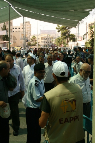 An EA looks on at the masses gathering to go to Friday Prayers. Over 22,300 people crossed the Bethlehem Checkpoint on the first Friday of Ramadan.