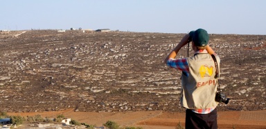 An EA photographs Israeli settlement outposts on the hills surrounding Yanoun. Photo EAPPI/A. Aguilar.