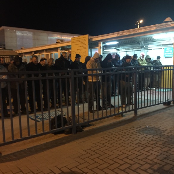 04.02.2016, Qalandia Checkpoint, Muslins praying in front of the Jerusalem part of the checkpoint. EAPPI _M. Carvalho.JPG
